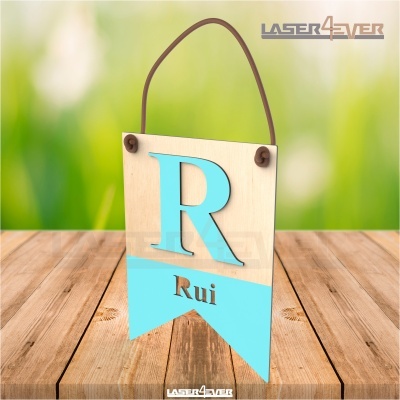Placa de madeira pendurada com letra R azul claro e nome Rui em fundo azul