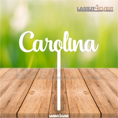 Topo de bolo com nome Carolina em cor branca sobre superfície de madeira e fundo verde desfocado