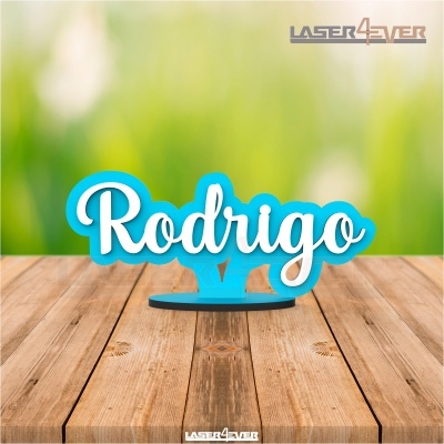 Nome 'Rodrigo' em acrílico azul e branco em base redonda sobre madeira