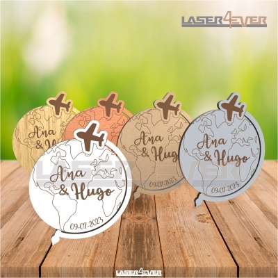Lembranças de madeira com formato de globo terrestre e avião, com nomes Ana & Hugo e data 09-07-2023 gravados.