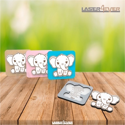 Peças de madeira com gravuras de elefantes coloridas sobre mesa de madeira com fundo verde desfocado