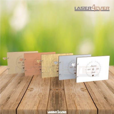 Cinco álbuns de fotos com capas variadas e gravações, dispostos numa mesa de madeira