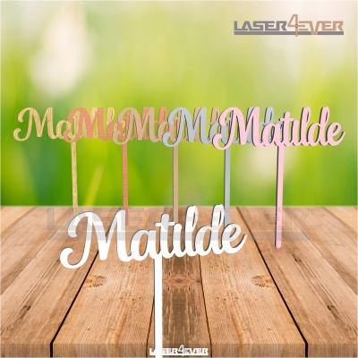 Cinco toppers para bolos com o nome Matilde em várias cores sobre mesa de madeira