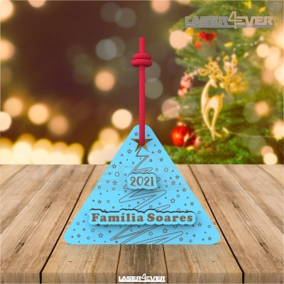 Etiqueta de Natal azul triangular com texto '2021 Família Soares' em mesa de madeira