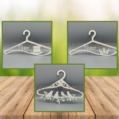 Três cabides decorativos de madeira branca com gravações e design de pássaros