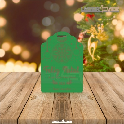 Etiqueta verde de cartão com texto de Natal sobre mesa de madeira com fundo festivo desfocado