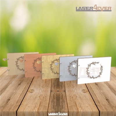 Cinco caixas retangulares coloridas com textura de madeira e decoração de ramos em cima de mesa de madeira