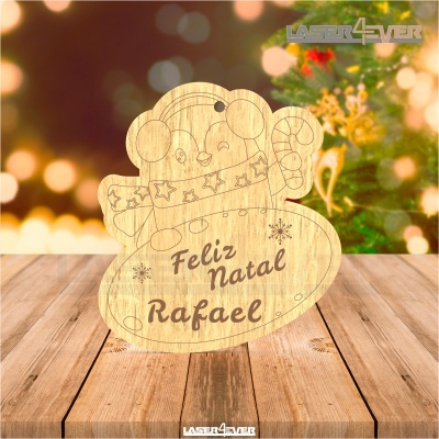 Boneco de neve de madeira gravado com texto de Natal sobre mesa de madeira