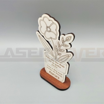 Suporte decorativo em madeira com placa branca em forma de flor e texto gravado.