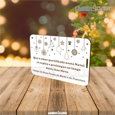 Cartão decorativo de Natal com mensagem e desenhos festivos em suporte sobre superfície de madeira