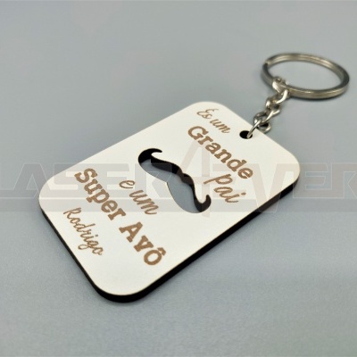 Chaveiro retangular branco com texto em castanho e desenho de bigode preto