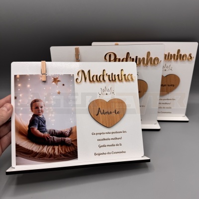 Três molduras de fotos brancas com decorações em madeira e imagem de bebé