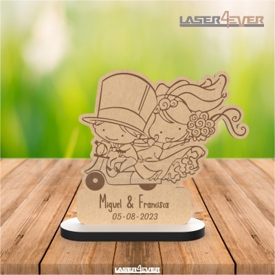 Peça decorativa de madeira com casal de noivos gravado