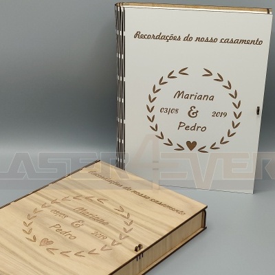 Dois livros com capas de madeira gravadas com texto e desenhos, num fundo cinza