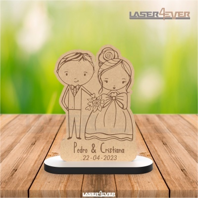 Figura decorativa de madeira com desenho de casal de noivos e texto gravado a laser