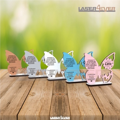 Lembranças em acrílico em forma de borboleta coloridas com texto, sobre madeira