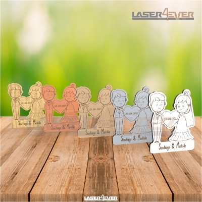 Figuras decorativas de casal com data e nomes sobre mesa de madeira