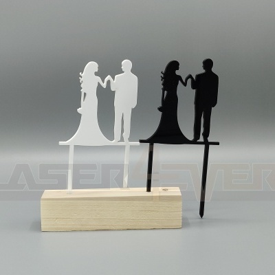 Enfeites de bolo de acrílico branco e preto em forma de casal, sobre madeira clara