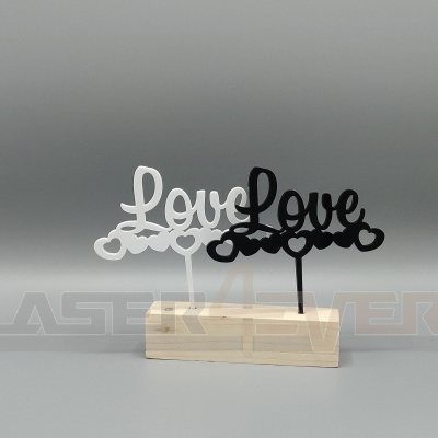 Ornamentos decorativos com a palavra 'Love' em branco e preto numa base de madeira clara