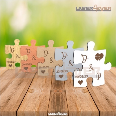 Peças de puzzle em madeira e branco com letras e data, sobre superfície de madeira