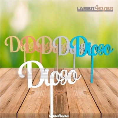 Toppers para bolos com o nome 'Diogo' em várias cores sobre mesa de madeira