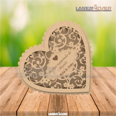 Caixa decorativa de madeira em forma de coração com padrão recortado e inscrição personalizada.