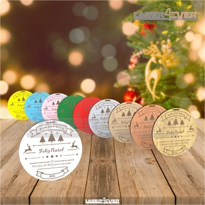 Etiquetas circulares de Natal coloridas alinhadas sobre madeira com árvore de Natal ao fundo