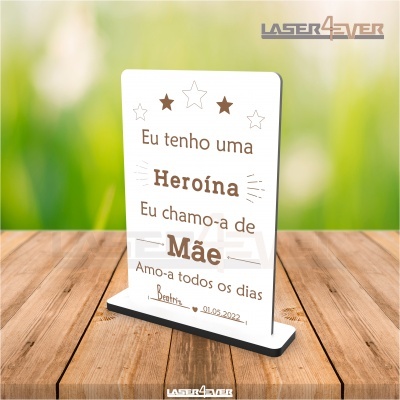 Placa decorativa branca com texto em português sobre superfície de madeira