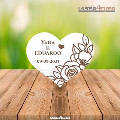 Cartão coração branco com nomes e data em superfície de madeira