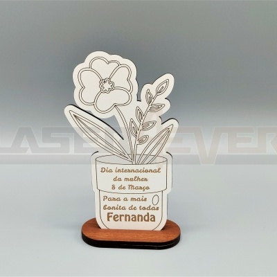 Decoração em madeira com flor e texto sobre base castanha escura