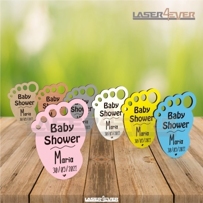 Placas em forma de pé de bebé coloridas com texto Baby Shower Maria 30/03/2021 sobre madeira