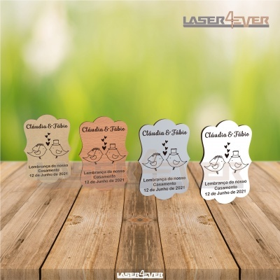 Quatro souvenirs de casamento em madeira com texto e desenho de pombos em duas cores diferentes