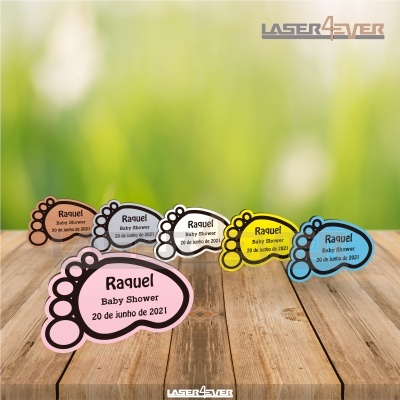 Etiquetas em forma de pé de bebé coloridas com texto para baby shower, sobre madeira