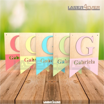 Placas de madeira coloridas com letras e nome 'Gabriela' sobre mesa de madeira