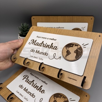 Suporte de madeira para chaves com texto 'Aqui mora a melhor Madrinha do Mundo Com Amor Sófia' e globo terrestre gravado