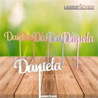 Toppers para bolo com o nome Daniela em várias cores metálicas sobre madeira