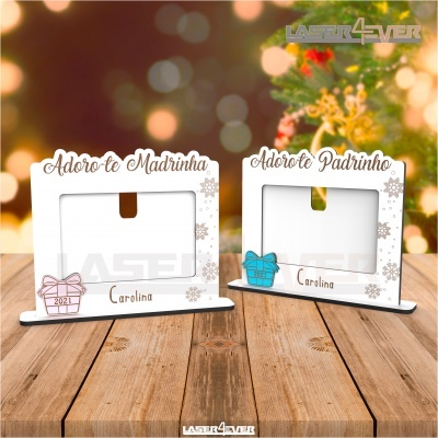 Dois porta-fotos brancos com mensagens para madrinha e padrinho sobre mesa de madeira