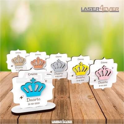 Lembranças de crisma com coroas coloridas em base branca sobre madeira