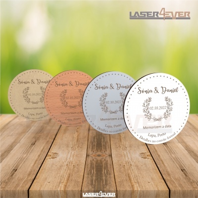 Placas circulares decorativas com texto personalizado e desenho floral em várias cores sobre mesa de madeira.