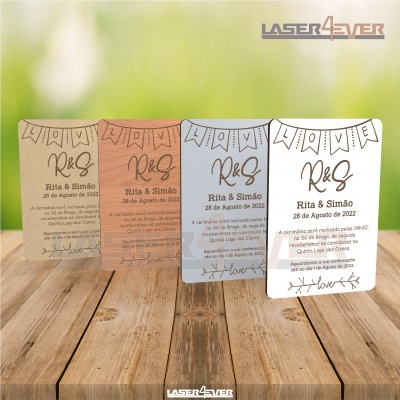 Cartões de convite para casamento de várias cores sobre mesa de madeira