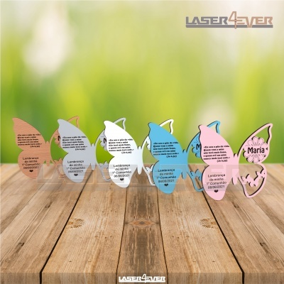 Lembranças acrílicas em forma de borboleta nas cores rosa, branco e azul com mensagens impressas, sobre superfície de madeira