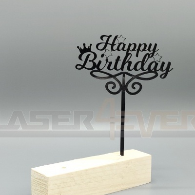 Topo de bolo preto com texto 'Happy Birthday' em base de madeira clara