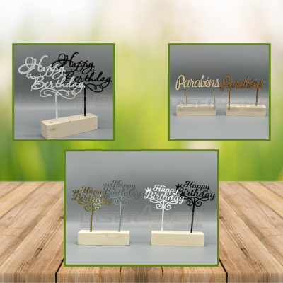 Decorações de bolo em madeira com mensagens de aniversário em várias cores sobre base retangular