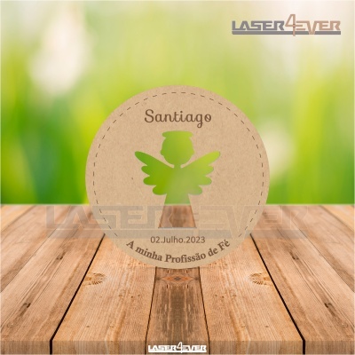 Etiqueta redonda em papel castanho com anjo verde e texto em castanho sobre mesa de madeira