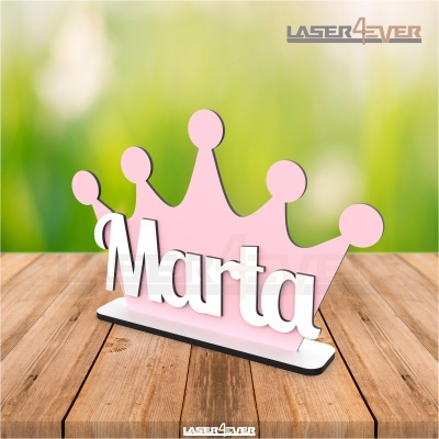 Peça decorativa nome Marta com coroa rosa em madeira sobre mesa de madeira clara