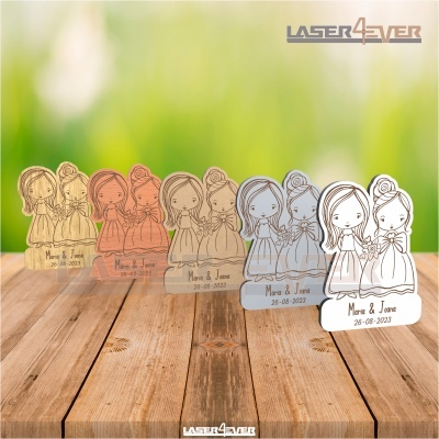 Lembranças de casamento em acrílico com design de noivas e texto Maria & João 26-08-2023 sobre madeira.