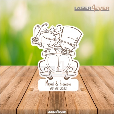Escultura decorativa em madeira clara com desenho de noivos num carro e texto personalizado.