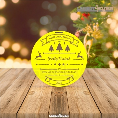Etiqueta redonda amarela com texto de Natal sobre mesa de madeira e fundo desfocado