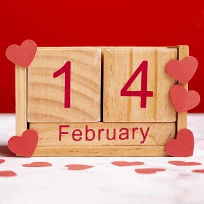 Calendário de bloco de madeira com data 14 February decorado com corações vermelhos