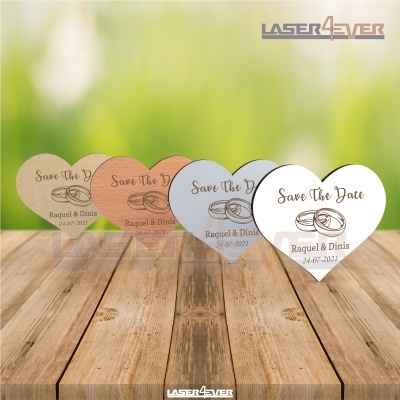 Cartões em forma de coração com texto 'Save The Date', nomes e data sobre mesa de madeira